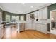 Bright kitchen with hardwood floors, white cabinetry, stainless appliances, and adjacent dining area at 4710 Mcintosh Dr, Cumming, GA 30040