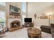 Cozy living room with a fireplace, large windows, and neutral carpet at 4710 Mcintosh Dr, Cumming, GA 30040