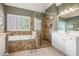 A luxurious bathroom featuring a soaking tub, glass-enclosed shower, and double vanity sinks at 4710 Mcintosh Dr, Cumming, GA 30040