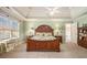 Spacious main bedroom featuring a tray ceiling, ceiling fan, and natural light from large windows at 4710 Mcintosh Dr, Cumming, GA 30040