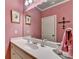 Bathroom with pink walls, sleek white vanity, and decorative mirror and accents at 2510 Bent Creek Way, Cumming, GA 30041