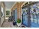 Inviting front porch with rocking chairs, blue door with floral wreath, and brick flooring at 2510 Bent Creek Way, Cumming, GA 30041