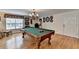 Bright game room with hardwood floors, a pool table under a chandelier, and decorative wall art at 2510 Bent Creek Way, Cumming, GA 30041