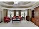 Comfortable living room featuring large windows, tray ceiling, and hardwood furniture at 2510 Bent Creek Way, Cumming, GA 30041