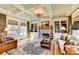 Sophisticated living room with built-in bookshelves, a stone fireplace, hardwood floors, and large windows at 2510 Bent Creek Way, Cumming, GA 30041