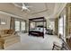 Spacious main bedroom with a four-poster bed, sitting area, and a ceiling fan at 2510 Bent Creek Way, Cumming, GA 30041