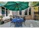 Covered outdoor patio with brick accents, a dining table, and comfortable seating area at 2510 Bent Creek Way, Cumming, GA 30041