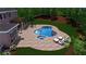 An in-ground kidney-shaped pool is surrounded by seating, a pergola, and beautiful landscaping at 2510 Bent Creek Way, Cumming, GA 30041