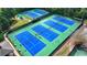Aerial view of a well-maintained tennis court complex, surrounded by lush landscaping at 2510 Bent Creek Way, Cumming, GA 30041