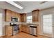 Modern kitchen featuring stainless steel appliances, light wood cabinets, and light stone countertops at 3285 Watson Gate Rd, Loganville, GA 30052