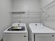 Bright laundry room with side-by-side washer and dryer, and built-in shelving at 3285 Watson Gate Rd, Loganville, GA 30052