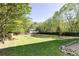Expansive backyard with lush green grass, mature trees, and a wooden privacy fence at 55 Maple Leaf Ct, Dallas, GA 30157