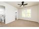 Bright bedroom featuring a ceiling fan, neutral carpet, and a window providing ample natural light at 55 Maple Leaf Ct, Dallas, GA 30157