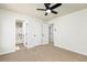 Carpeted bedroom with ceiling fan, bathroom access, and closet, creating a cozy retreat at 55 Maple Leaf Ct, Dallas, GA 30157