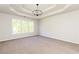 Spacious bedroom with tray ceiling, modern light fixture, and large window at 55 Maple Leaf Ct, Dallas, GA 30157