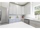 Well-lit kitchen features stainless steel appliances, gray cabinets, and white countertops and backsplash at 55 Maple Leaf Ct, Dallas, GA 30157