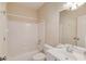 Well-lit bathroom with shower-tub combination features a single sink vanity, white fixtures and walls, and tile flooring at 5808 Deer Crossing Dr, Sugar Hill, GA 30518