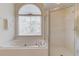 Bathroom featuring a soaking tub, a shower and a window with blinds at 5808 Deer Crossing Dr, Sugar Hill, GA 30518