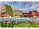 Community pool featuring a water slide, plenty of seating, and green grass at 5808 Deer Crossing Dr, Sugar Hill, GA 30518
