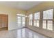 Bright dining area with tile floor features an elegant light fixture and backyard views through large windows and French doors at 5808 Deer Crossing Dr, Sugar Hill, GA 30518