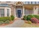Inviting front entrance with a navy blue door, stone accents, and lush landscaping at 5808 Deer Crossing Dr, Sugar Hill, GA 30518