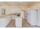 Modern kitchen with island features white cabinets, stainless appliances, tile backsplash, and tile flooring at 5808 Deer Crossing Dr, Sugar Hill, GA 30518