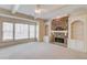 Bright living room featuring neutral walls, carpet, fireplace and a large window at 5808 Deer Crossing Dr, Sugar Hill, GA 30518