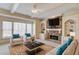 Comfortable living room with built-in shelves, a stone fireplace, and a large window at 5808 Deer Crossing Dr, Sugar Hill, GA 30518
