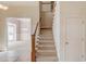 Bright foyer featuring a staircase with carpeted steps and wood railing leading to the upper level at 5808 Deer Crossing Dr, Sugar Hill, GA 30518
