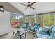 Comfortable sunroom features modern ceiling fan, plush seating, and scenic views of backyard and wooded landscape at 2051 Candlewood Ne Ct, Marietta, GA 30066