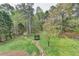 Spacious backyard featuring a stone pathway, play area, mature trees, and fenced perimeter at 417 Wood Branch St, Woodstock, GA 30188
