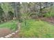 Lush backyard featuring a stone pathway, storage shed, play area, mature trees, and fenced perimeter at 417 Wood Branch St, Woodstock, GA 30188