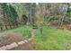 Expansive backyard showcasing a stone pathway, storage shed, surrounded by lush greenery, and fenced perimeter at 417 Wood Branch St, Woodstock, GA 30188