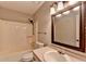 This bathroom features a shower-tub combo, large mirror, and neutral color palette at 417 Wood Branch St, Woodstock, GA 30188