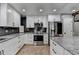 Modern kitchen with stainless steel appliances, white cabinets, granite countertops, and black subway tile backsplash at 417 Wood Branch St, Woodstock, GA 30188