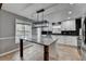 Bright kitchen with large island, white cabinets, stainless steel appliances, and eat in area with large windows at 417 Wood Branch St, Woodstock, GA 30188