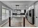 Modern kitchen features white cabinets, stainless steel appliances, a large island, and black subway tile backsplash at 417 Wood Branch St, Woodstock, GA 30188