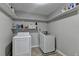 Well-lit laundry room features a washer, dryer and shelving for easy organization and storage at 417 Wood Branch St, Woodstock, GA 30188