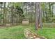 Backyard storage shed with a stone path, surrounded by a wooden fence and trees for added privacy at 417 Wood Branch St, Woodstock, GA 30188