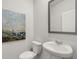 Clean bathroom with a white pedestal sink, toilet and paint complemented by a gray-framed mirror at 4958 Jatoba Rd, Acworth, GA 30101