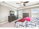 Cozy bedroom featuring a ceiling fan, neutral walls, and large windows for natural light at 7620 Stoneridge Dr, Atlanta, GA 30328