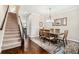 Elegant dining room with hardwood floors, chandelier lighting, and staircase access at 7620 Stoneridge Dr, Atlanta, GA 30328