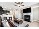 Cozy living room with a fireplace, ceiling fan, and open layout to the kitchen and staircase at 7620 Stoneridge Dr, Atlanta, GA 30328