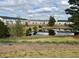 Scenic view of the community pond surrounded by townhomes with lush greenery, creating a peaceful retreat at 950 Sunny Lake Dr, Lawrenceville, GA 30043