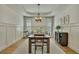 Elegant dining room featuring wood floors, wainscoting, and a modern chandelier over a large table at 2674 Hosanna Dr, Powder Springs, GA 30127