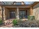 Charming front porch with brick flooring, stone supports, and seating, offering a welcoming entrance to the home at 2674 Hosanna Dr, Powder Springs, GA 30127