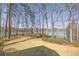 Waterfront backyard with lake view, mature trees and lush landscaping at 2674 Hosanna Dr, Powder Springs, GA 30127