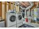 Basement laundry room with a front load washer and dryer set and modern utility shelving at 2674 Hosanna Dr, Powder Springs, GA 30127