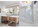 Bright bathroom features double vanity, modern lighting, herringbone tile accent, and a luxurious glass-enclosed shower at 80 Seville Chase, Atlanta, GA 30328