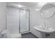 Updated basement bathroom features a shower with sliding glass doors and a pedestal sink at 80 Seville Chase, Atlanta, GA 30328